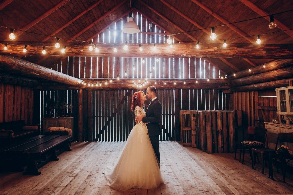 Newly weds hugging in a wooden barn