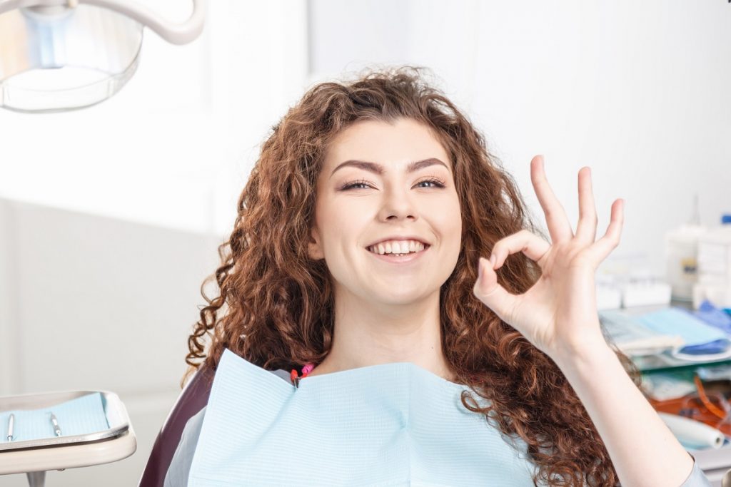 Woman smiling sitting on a dental chair