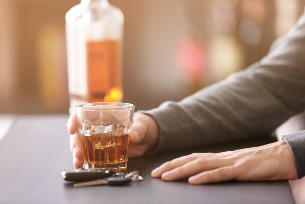 man drinking whiskey in a bar