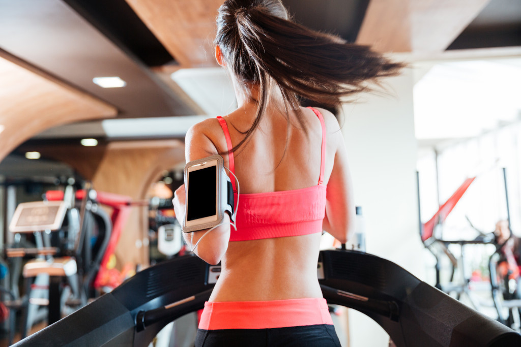 Woman workingout with a smartphone attached to her arms