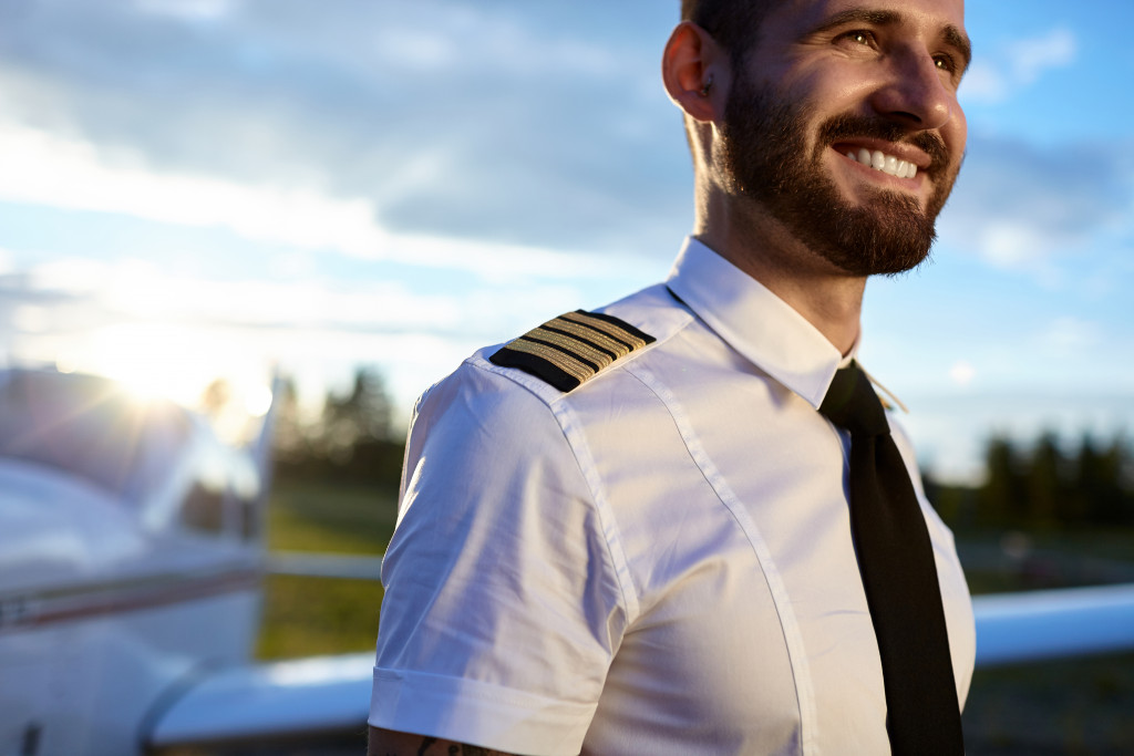 High ranking pilot smiles with plane behind him